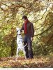 a_young_man_playing_with_his_dog_amongst_the_autumn_leaves_LV11598031.jpg