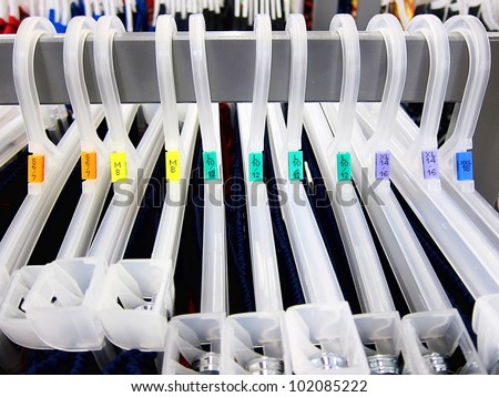 stock-photo-clothing-sizes-multiple-coat-hangers-in-a-store-with-size-tags-102085222.jpg
